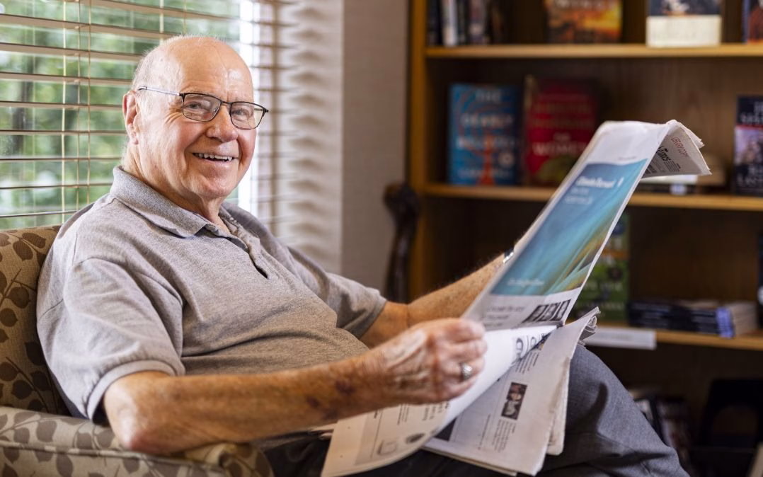 An independent living resident relaxes with the newspaper at Willow Brook Run in Delaware, Ohio, where quiet reading nooks support an active senior lifestyle.